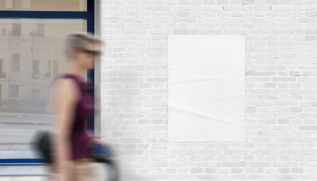 Vertical poster mockup with passing woman. Clean surface for advertising, graphic design, and promotional display in city settingの写真素材