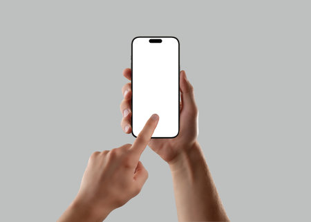 Man hand holding smartphone with blank screen and finger touch gesture on gray background. Perfect mockup for app design, UI testing, or mobile interfaceの写真素材