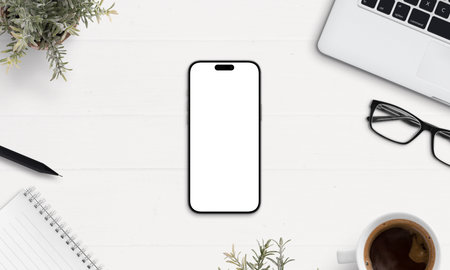 op view smartphone mockup on white desk with coffee, laptop, notebook, and glasses. Perfect for app design, UI presentation, or brandingの写真素材