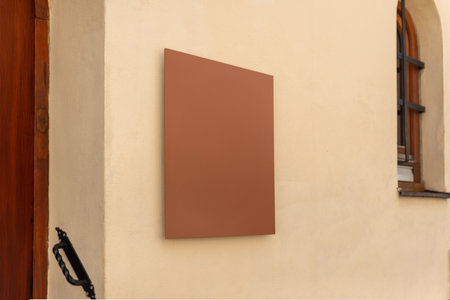 Minimalist brown square sign on beige wall in sunlight, ideal for branding, nameplate design or small business identityの写真素材