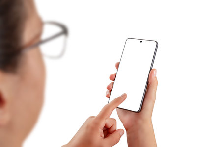 Woman interacting with smartphone, blank screen ideal for app mockups, user interface previews, or digital product presentationsの写真素材