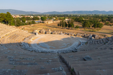 Wide view of the ancient theatre of Philippi and surrounding rural landscape, blending ancient...
