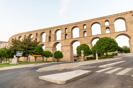 Majestic Ottoman-era aqueduct âKamaresâ in Kavala, with sweeping arches spanning the historic city under a golden sunset skyの写真素材