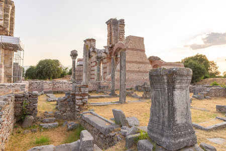 Interior ruins of Basilica B in Philippi, with preserved columns, arches, and decorative stonework under the sunset lightの写真素材