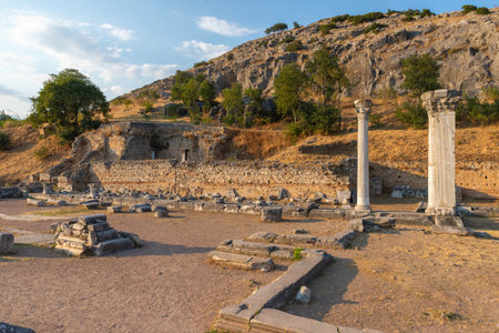 Roman forum ruins of Philippi with two standing columns and ancient walls at the foot of the acropolis hillの写真素材