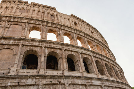 Close view of the Colosseum arches in Rome, Italy, revealing weathered stone, textures and timeless...