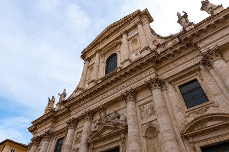 Baroque facade of a historic church in Rome with ornate statues, columns and Latin inscriptionの写真素材