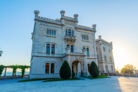 Castle of Miramare in Trieste, Italy, elegant historic building with towers, set against sunset skyの写真素材