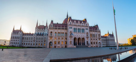 Wide panoramic view of Hungarian Parliament in Budapest with evening light and reflection in water foreground.の写真素材