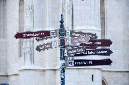 Street signpost with tourist information and direction to Buda Castle, Fishermanâ€™s Bastion,...
