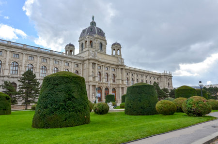 Kunsthistorisches Museum Vienna exterior with dome and trimmed gardens under cloudy sky, Austriaの写真素材