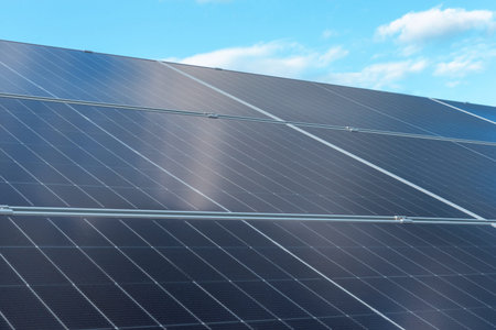 Rows of modern photovoltaic solar panels generating renewable energy under bright daylight sky