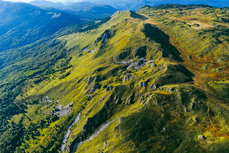 Panoramic aerial view of mountain ridges and valleys glowing in golden light