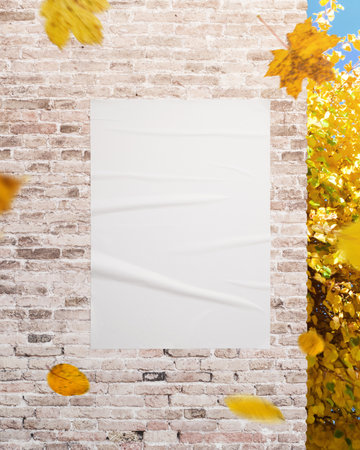 Vertical white poster on textured wall with yellow leaves, perfect for advertising, campaign visuals and design presentationsの写真素材