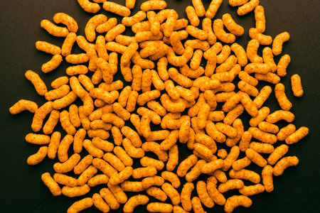 Round layout of peanut puff snacks on dark background, creative minimal composition for packaging, food design, and commercial advertisingの写真素材