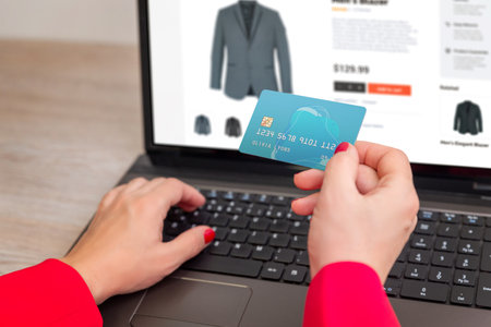 Making online purchase using credit card on laptop, shopping for clothes through e-commerce website, secure payment and internet retail conceptの写真素材