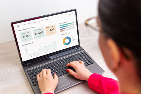Business woman typing on laptop with analytics dashboard showing revenue, charts, and traffic sources, concept of digital marketing and financial growthの写真素材