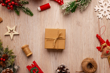 Minimalist Christmas flat lay with a wrapped gift box surrounded by festive decorations, ideal for holiday campaigns, gift promotions and seasonal product advertisingの写真素材