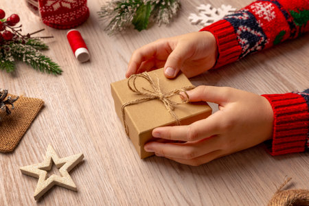 Eco friendly gift box wrapped with twine among natural Christmas decorations, ideal for sustainable packaging concepts and handmade product brandingの写真素材