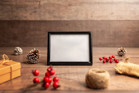 Blank photo frame in a rustic Christmas flat lay with pinecones and berries, perfect for artwork previews, holiday cards and seasonal brandingの写真素材