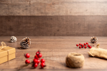 Christmas flat lay background with pinecones, berries and rustic wood surface, perfect for holiday designs, copy space layouts, winter campaigns and festive brandingの写真素材