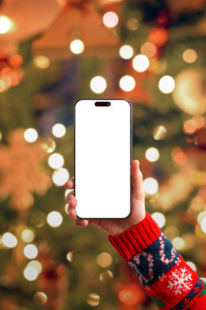 Christmas phone mockup with bright bokeh lights and festive sweater, vertical holiday marketing, seasonal designs, mobile apps and winter promotional visualsの写真素材