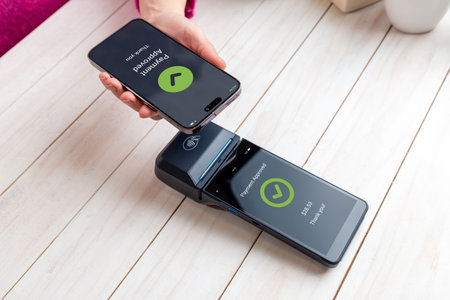Smartphone displays payment approval after a tap-to-pay transaction, confirming successful NFC mobile payment completed on the POS terminalの写真素材