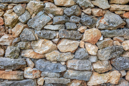Detail of an old wall made of natural stone blocks