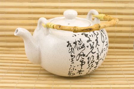 White teapot with hieroglyphs in east style on a supportの写真素材