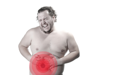 Pain in the abdomen. Gastritis. The overweight guy. White background.の写真素材