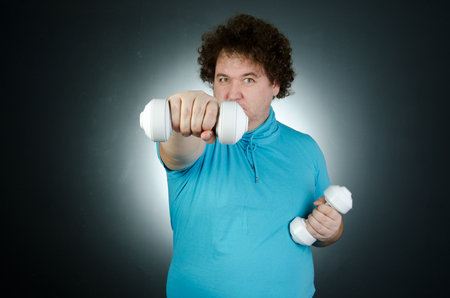 Funny fat man holding a dumbbell.の写真素材