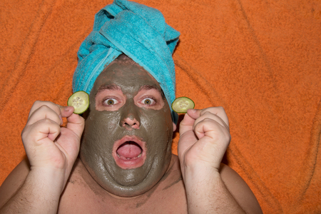 Spa and facials. Funny fat man and clay mask.の写真素材