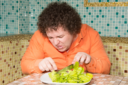 Hungry man and a plate of salad.の写真素材