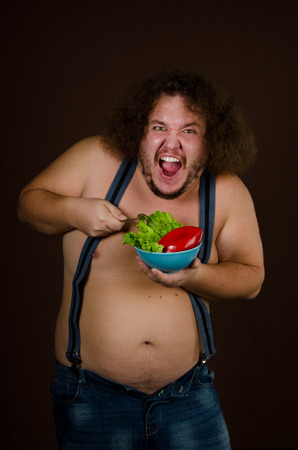 Diet. Fat guy and vegetable.の写真素材