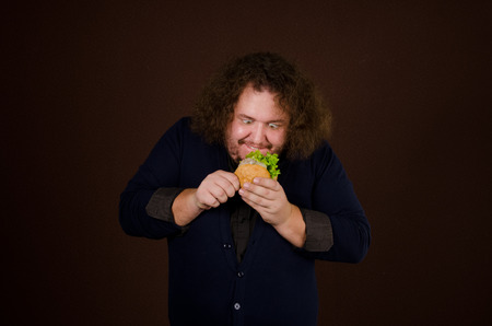 Hunger and dinner. Funny man with a hamburger. Food and hunger. Guy with burger. Healthy lifestyle and fast food.の写真素材