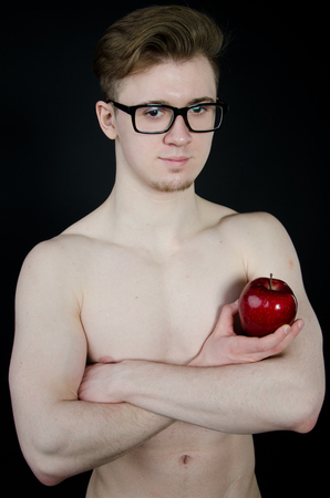 Man and a red apple. Young guy. Healthy lifestyle.の写真素材