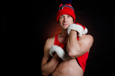 Sexy man at Christmas. Handsome man in red underwear undressing.の写真素材