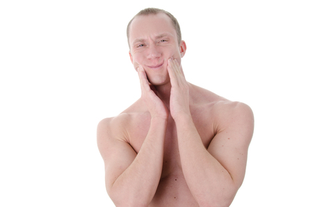 Toothache and attractive guy. The young man on a white background. Pain and tooth decay.の写真素材