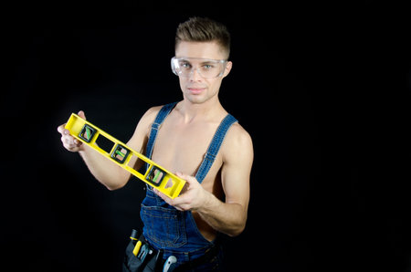 Handyman shirtless. Sexy guy and level. Handsome young guy. Portrait. Handyman shirtless. Smile and...