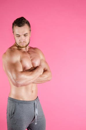 Young attractive bodybuilder. Guy with a beautiful muscular body, shirtless. Healthy lifestyle and gym.の写真素材