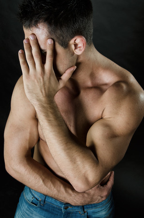 Handsome man covers his face with his hand. Business and stress. Problems at workの写真素材