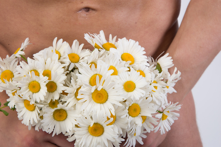 Handsome man and flowers. Love and romance. Naked man holding a flowers.の写真素材
