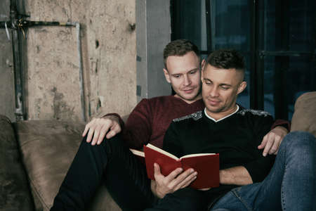 Friends at home reading books.の写真素材