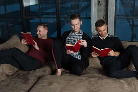 Friends at home reading books.の写真素材