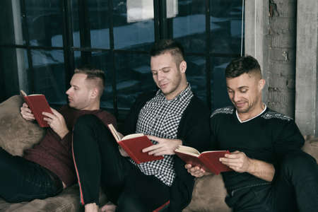 Friends at home reading books.の写真素材