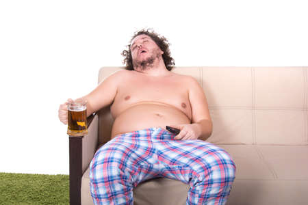 Funny fat man watching tv. Beer.の写真素材