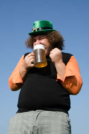 Funny fat guy is drinking beer.の写真素材