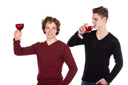 Holidays and weekends. Young attractive couple drinking red wine. White background.の写真素材