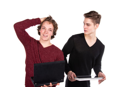 Study and work. Two young attractive students with laptops. White background.の写真素材