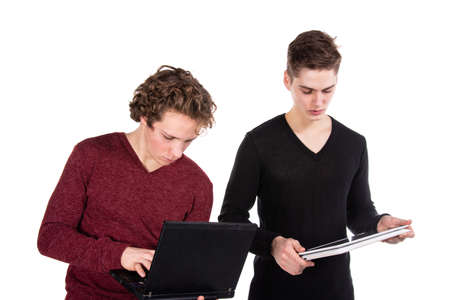 Study and work. Two young attractive students with laptops. White background.の写真素材
